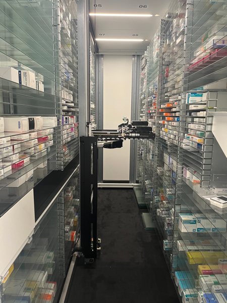 Vollautomatisches Warenlager der Lonetal Apotheke mit Kommissionierroboter zwischen zwei Regalreihen, in denen Arzneimittel lagern.
