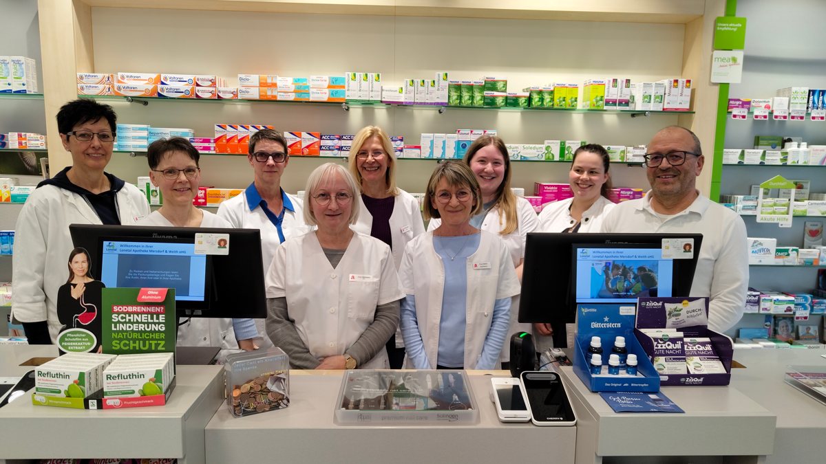 Das freundliche Team der Lonetal Apotheke in Niederstotzingen hinter dem HV-Tisch vor dem Arzneimittelregal